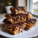A stack of homemade 5-ingredient protein bars made with oats and drizzled generously with melted dark chocolate.