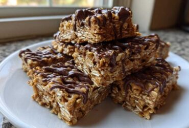 A stack of homemade 5-ingredient protein bars made with oats and drizzled generously with melted chocolate.