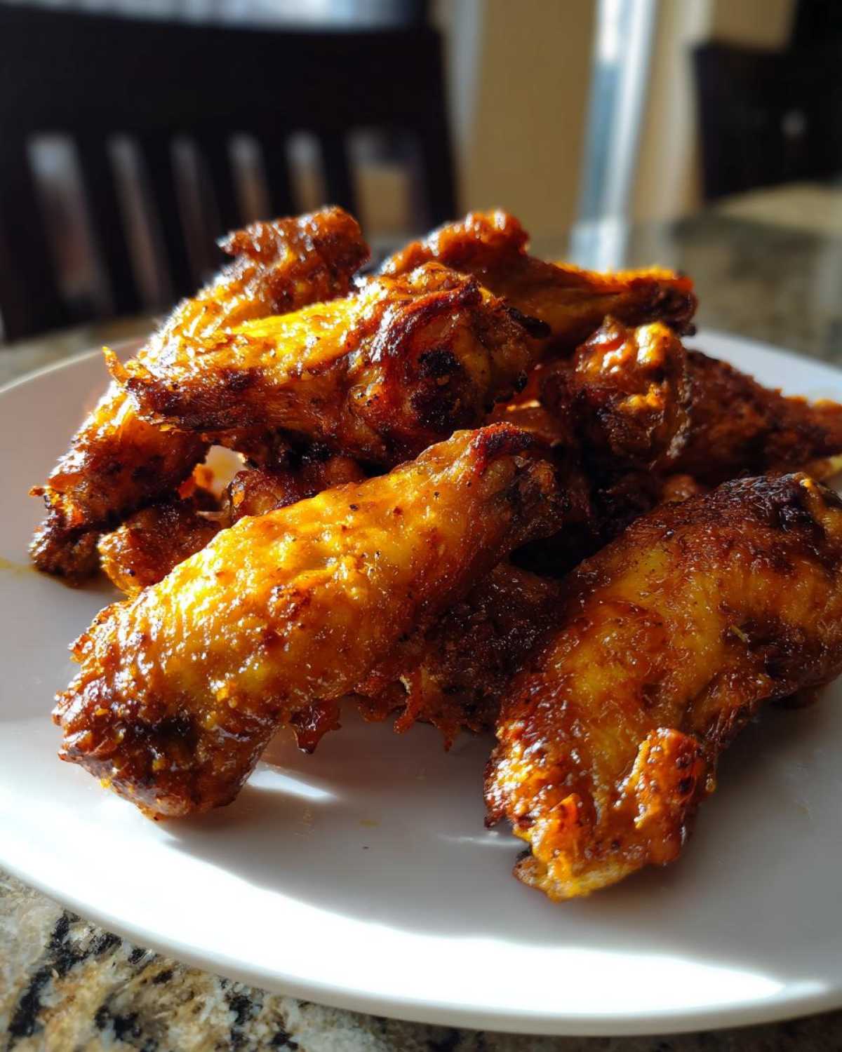 Close-up of a pile of perfectly cooked, crispy chicken wings seasoned with spices.