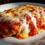 Close-up of a perfectly cooked Easy Chicken Parmesan cutlet topped with melted mozzarella and rich tomato sauce.