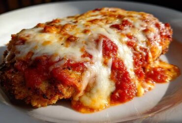 Close-up of a perfectly cooked Easy Chicken Parmesan cutlet topped with melted mozzarella and rich tomato sauce.