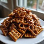 A mound of crunchy pretzels and waffle squares coated in glossy caramel for the toffee chex mix recipe.