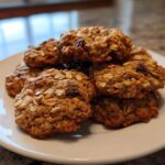 A stack of freshly baked, chewy oatmeal cookie treats piled high on a white plate.