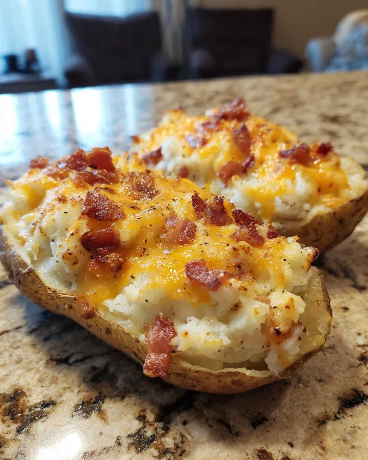 Two amazing twice baked potatoes stuffed with creamy filling, melted cheddar cheese, and crispy bacon bits.