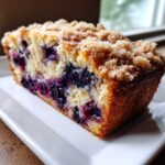 Close-up of a moist slice of blueberry banana bread topped with crunchy streusel.