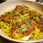 Four pieces of pan-seared creamy lemon chicken smothered in a rich, yellow sauce and topped with fresh parsley.
