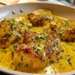 Four pieces of seared chicken breasts smothered in a rich, yellow creamy lemon chicken sauce and topped with fresh parsley.