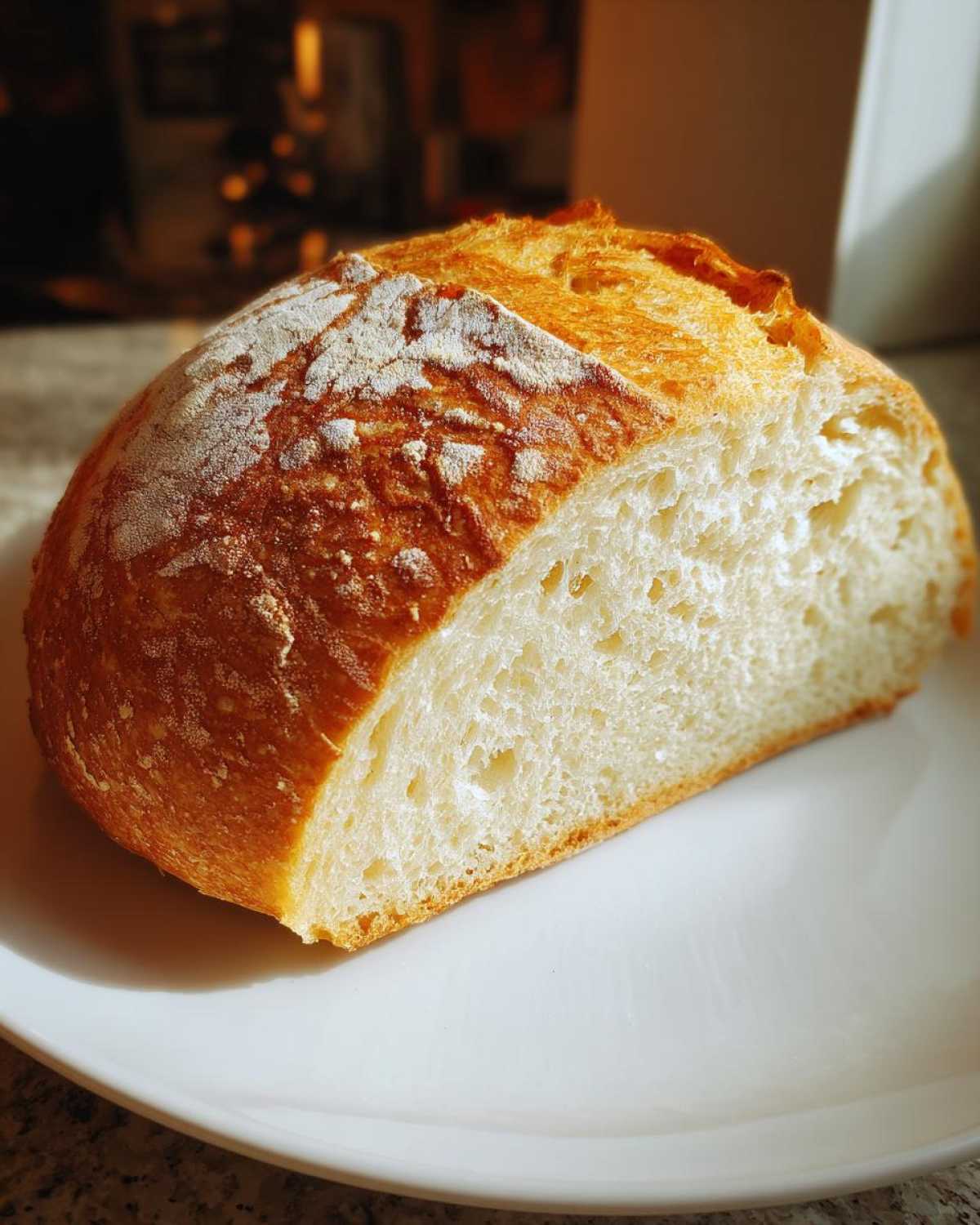 Close-up of a freshly baked Italian bread loaf, showing a golden, flour-dusted crust and airy white crumb.
