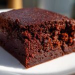 A close-up, macro shot showcasing the incredibly fudgy texture of a single square of sweet potato brownies.