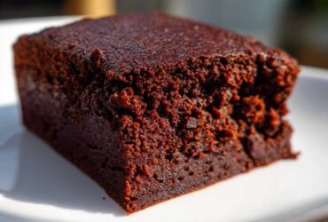A close-up, macro shot showcasing the incredibly fudgy texture of a single square of sweet potato brownies.