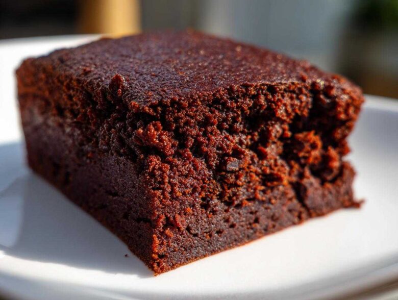 A close-up, macro shot showcasing the incredibly fudgy texture of a single square of sweet potato brownies.