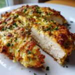 Cross-section view of juicy Garlic parmesan chicken bake with a golden, melted cheese topping and parsley.