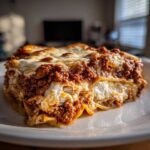 Close-up of a perfectly layered slice of homemade lasagna with rich meat sauce and melted cheese.