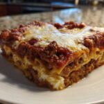 A thick, square slice of Lasagna with Cottage Cheese showing layers of pasta, meat sauce, and white cheese filling.