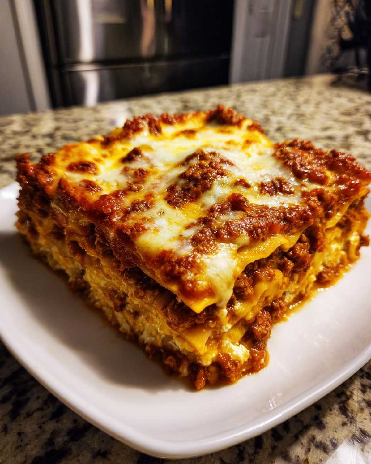 A thick, square slice of baked Lasagna with Cottage Cheese, featuring layers of pasta, meat sauce, and melted cheese topping.