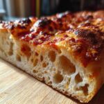 Close-up cross-section showing the airy, open crumb structure of sourdough discard pizza dough.