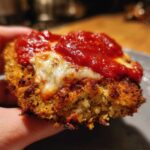 Close-up of a perfectly cooked piece of Air Fryer Chicken Parmesan, showing crispy coating, melted mozzarella, and rich tomato sauce.