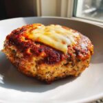 Close-up of a perfectly cooked Air Fryer Turkey Burger patty topped with melted white cheese.