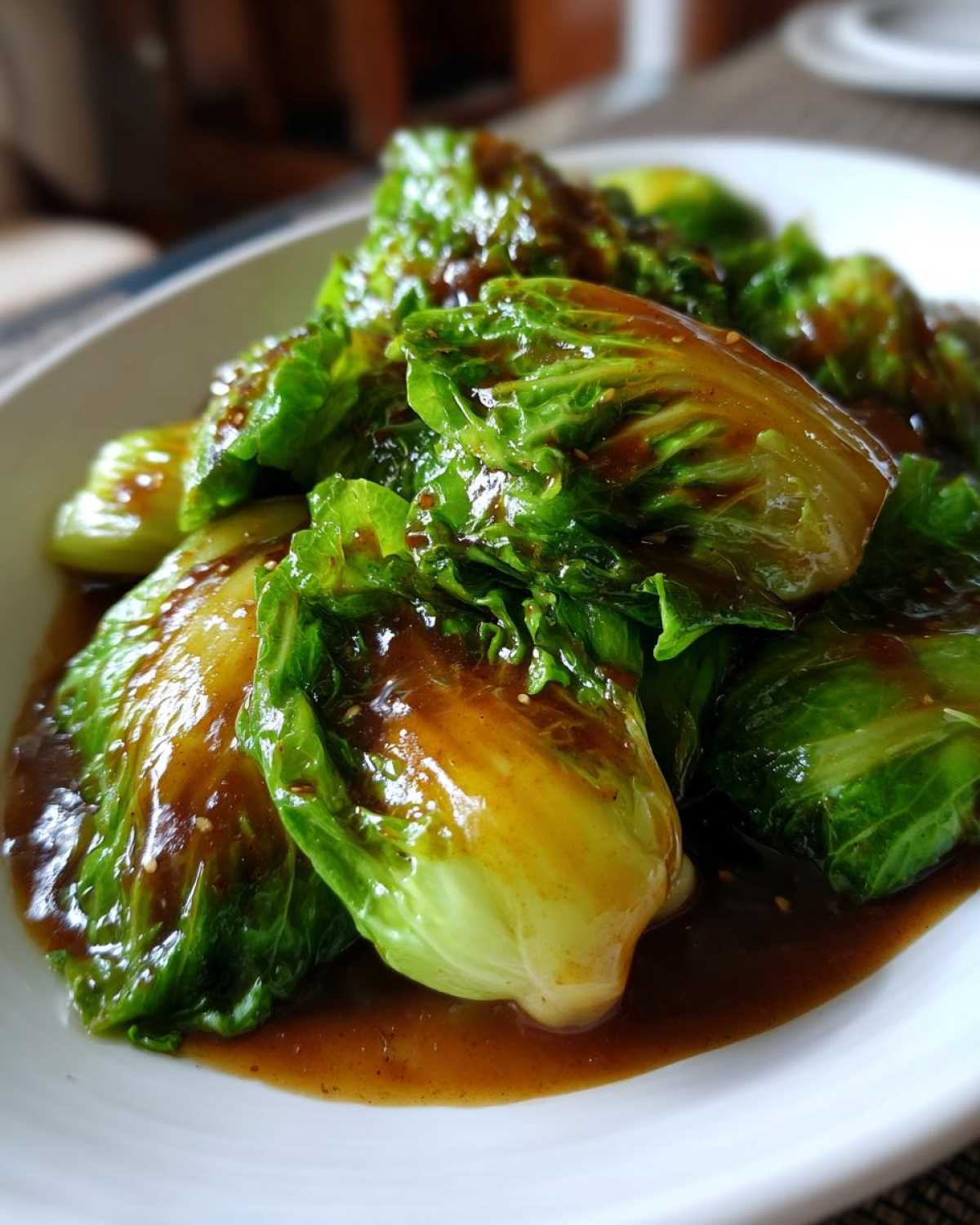 Close-up of vibrant green cabbage wedges coated in a rich garlic ginger sauce for Cabbage Stir Fry.