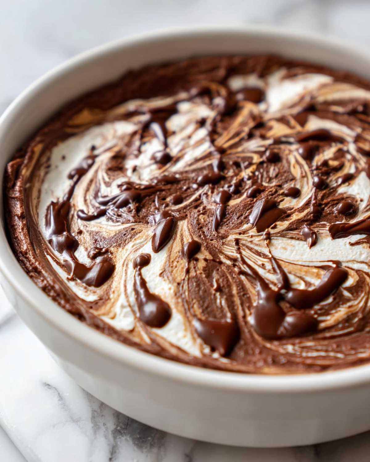 Close-up of Chocolate Peanut Butter Cheesecake Dip swirled with chocolate sauce in a white serving dish.