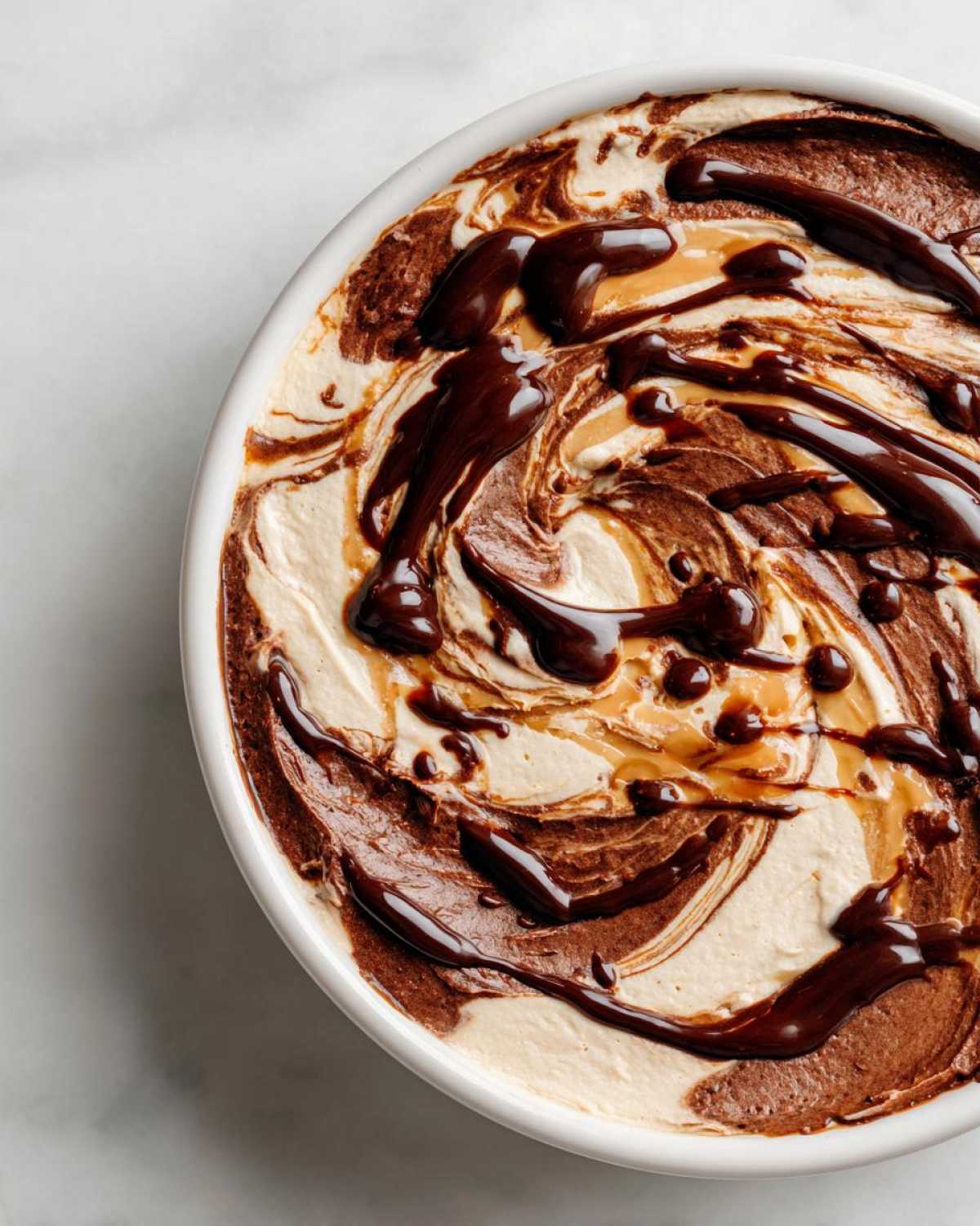 Overhead view of Chocolate Peanut Butter Cheesecake Dip swirled with chocolate sauce.