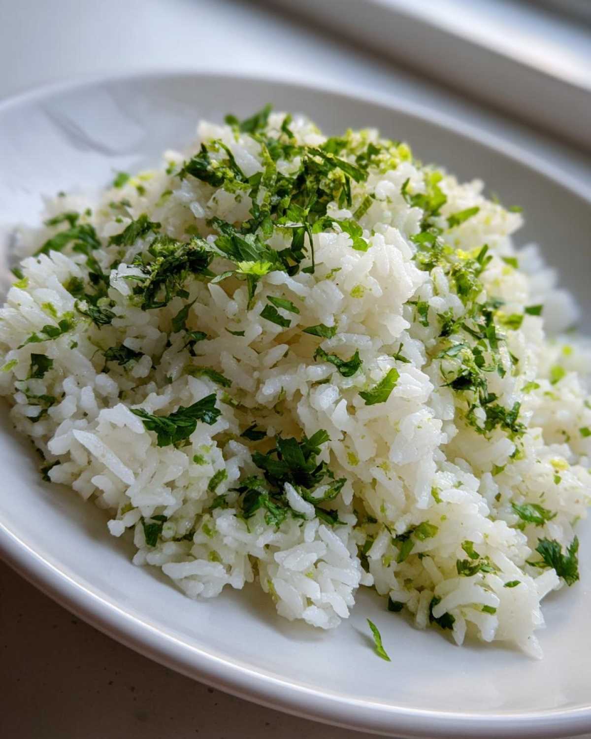 A close-up of fluffy white rice topped generously with chopped cilantro and lime zest, perfect for Cilantro Lime Rice for Burrito Bowls.