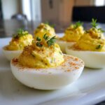 Close-up of Classic Deviled Eggs with Dill Pickle Relish, topped with paprika and fresh dill.