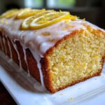 A moist loaf of Copycat Starbucks Iced Lemon Loaf, drizzled with thick white icing and topped with lemon slices.