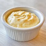 Close-up of creamy Copycat Taco Bell Chicken Quesadilla Sauce in a small white ramekin.