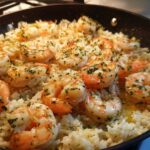 Close-up of Garlic Butter Shrimp and Rice Skillet, featuring plump shrimp seasoned with herbs in a black pan.