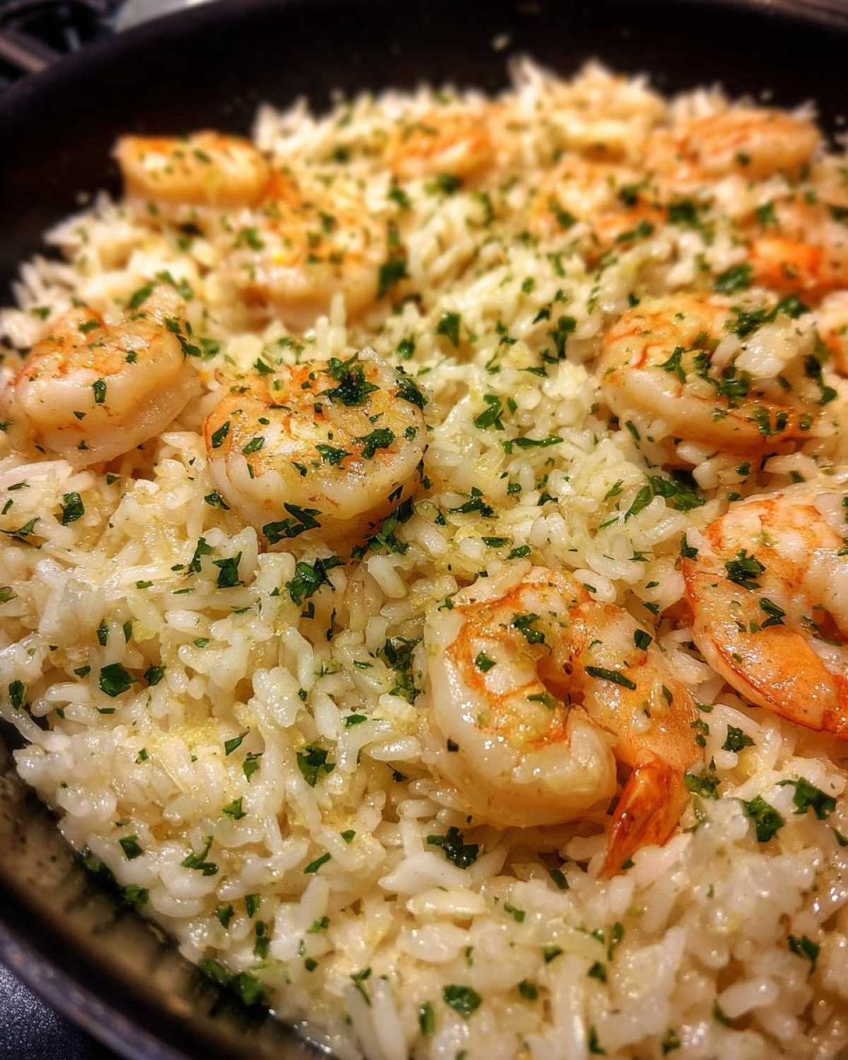 Close-up of Garlic Butter Shrimp and Rice Skillet topped with fresh parsley.