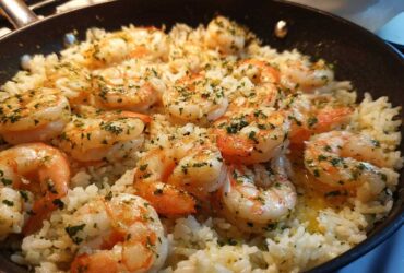 Close-up of Garlic Butter Shrimp and Rice Skillet, featuring plump shrimp seasoned with herbs in a black pan.