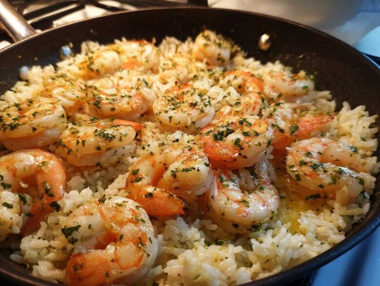Close-up of Garlic Butter Shrimp and Rice Skillet, featuring plump shrimp seasoned with herbs in a black pan.