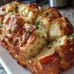 Close-up of freshly baked Garlic Parmesan Pull-Apart Bread, golden brown and topped with melted cheese and parsley.