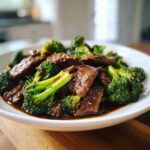 Close-up of tender slices of beef and bright green broccoli florets coated in a rich sauce, ready to eat Instant Pot Beef and Broccoli.
