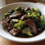 Close-up of tender beef slices and bright green broccoli florets coated in rich sauce for Instant Pot Beef and Broccoli.