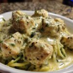 Close-up of Keto Chicken Alfredo featuring chunks of chicken breast smothered in creamy sauce over zucchini noodles.