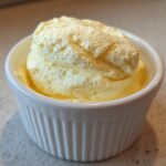 Close-up of light yellow, airy Keto Lemon Cheesecake Mousse served in a small white fluted ramekin.