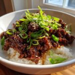 Close-up of Korean Ground Beef Bulgogi Bowls featuring savory ground beef over white rice, topped with green onions and sesame seeds.
