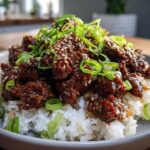 Close-up of Korean Ground Beef Bulgogi Bowls featuring saucy beef over white rice, garnished with sesame seeds and green onions.