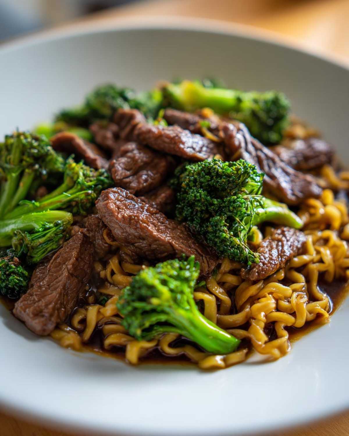 Close-up of savory One-Pot Beef and Broccoli Ramen Noodles in a white bowl.