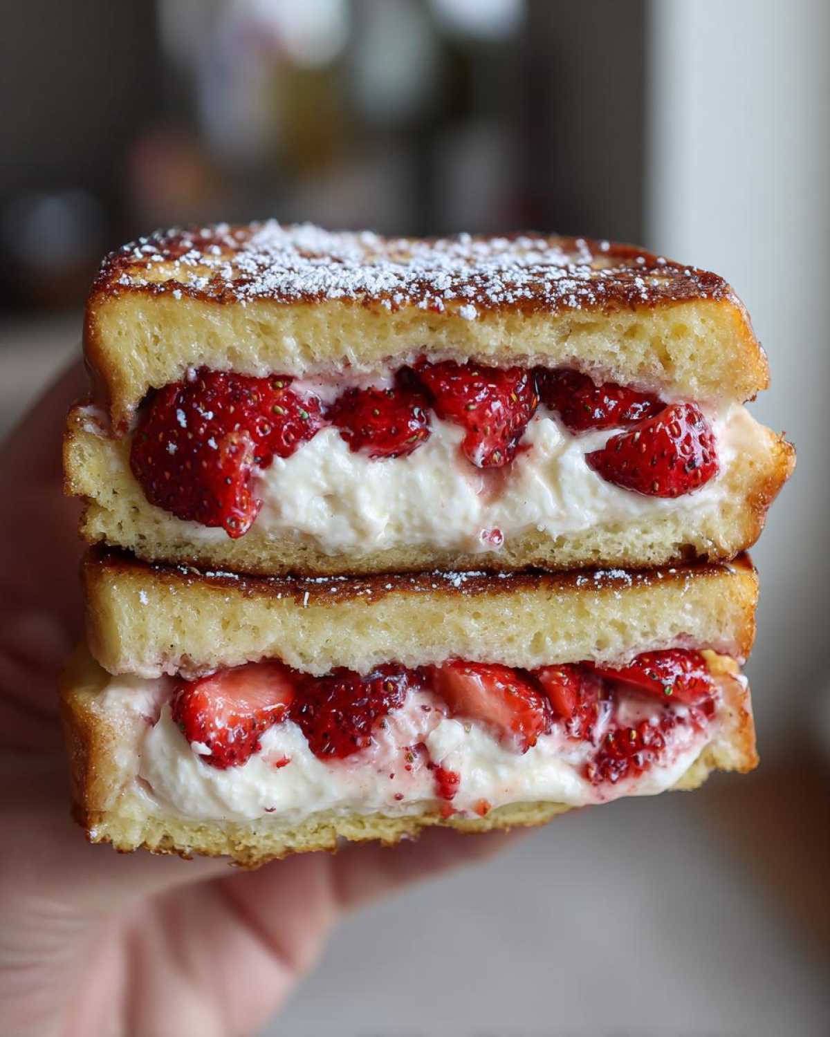 Close-up of Strawberry Cream Cheese Stuffed French Toast cut in half, showing thick cream cheese and strawberry filling.