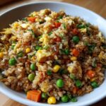 Close-up of flavorful Vegetable Fried Rice with Sesame Ginger Sauce, mixed with peas, carrots, corn, and scrambled egg.