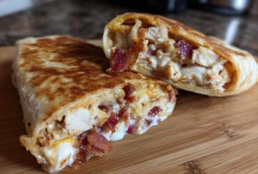 Two halves of a golden-brown Air Fryer Crispy Chicken Bacon Ranch Wrap showing the creamy filling of chicken, bacon, and ranch sauce.