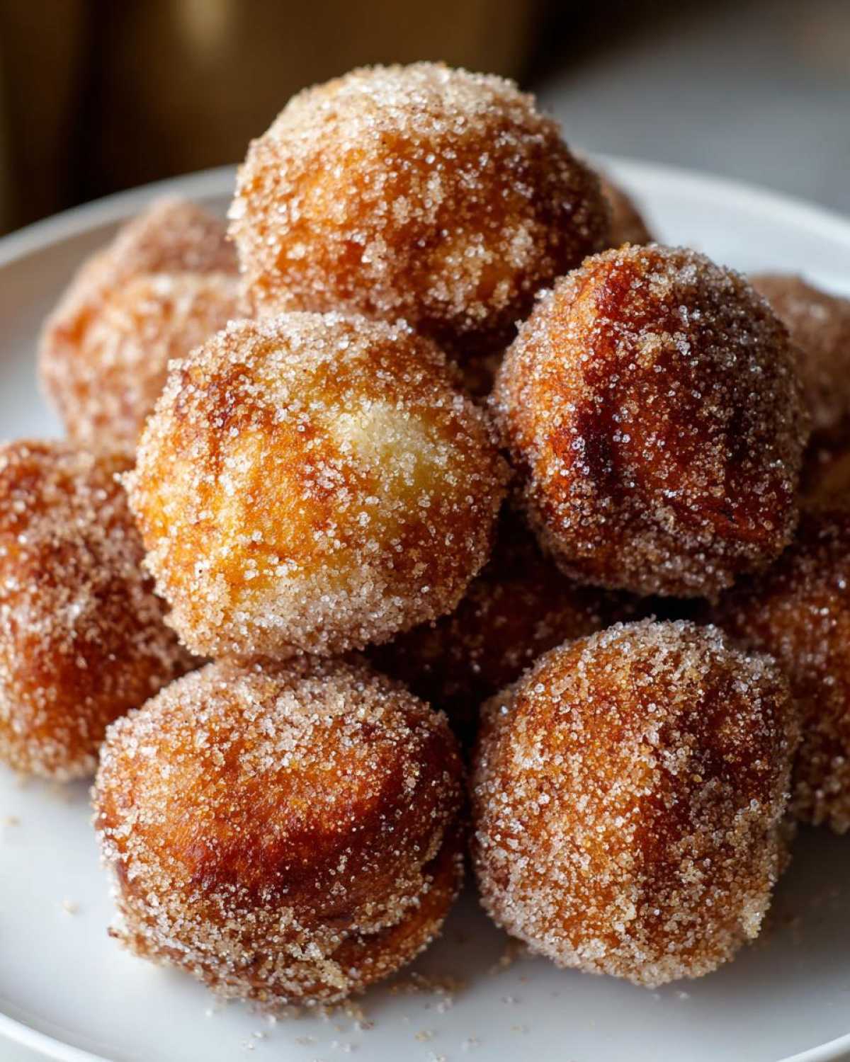 A close-up stack of golden brown Air Fryer Crispy Cinnamon Sugar Pretzel Bites coated heavily in sparkling sugar.