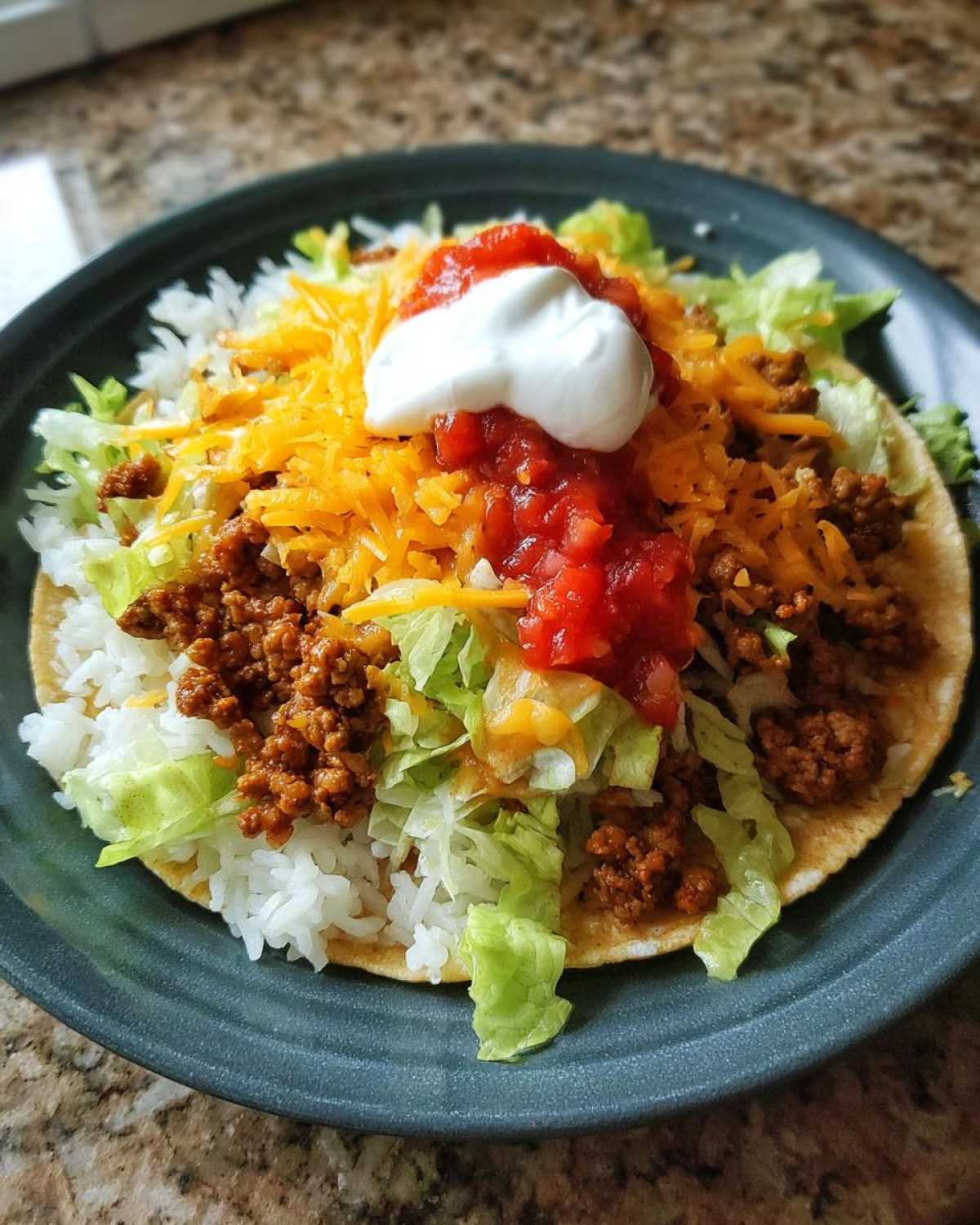 A fully loaded Air Fryer Crispy Turkey Taco Bowl featuring seasoned ground turkey, rice, lettuce, cheese, salsa, and sour cream.