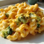 Close-up of creamy Copycat Café Broccoli Cheddar Mac featuring elbow macaroni and bright green broccoli florets coated in rich cheese sauce.