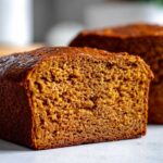 Cross-section view of a rich, dark brown loaf of Copycat Dark Brown Honey Wheat Bread showing its moist, dense crumb.