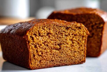 Cross-section view of a rich, dark brown loaf of Copycat Dark Brown Honey Wheat Bread showing its moist, dense crumb.