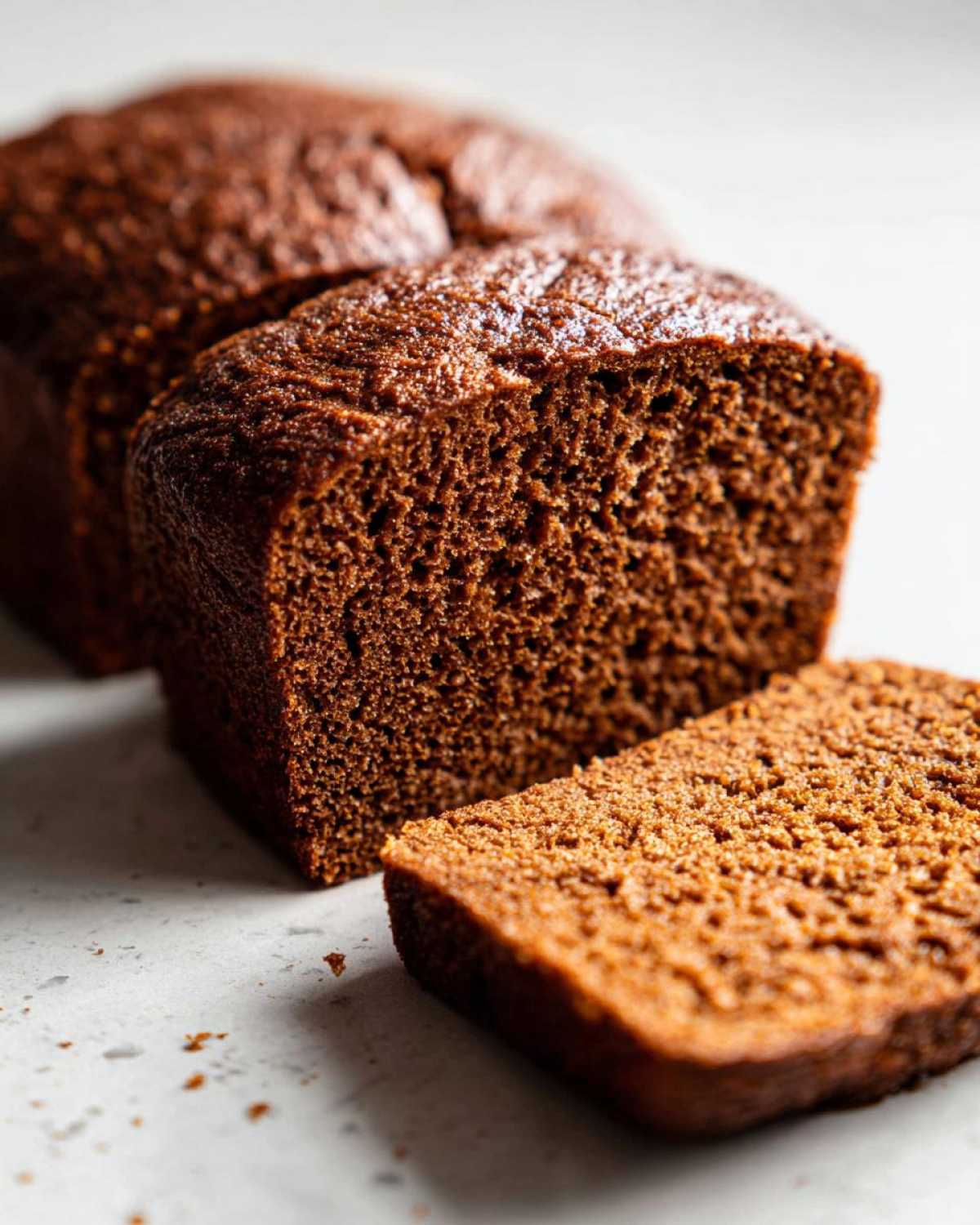 Close-up of sliced Copycat Dark Brown Honey Wheat Bread showing its dense, moist crumb texture.